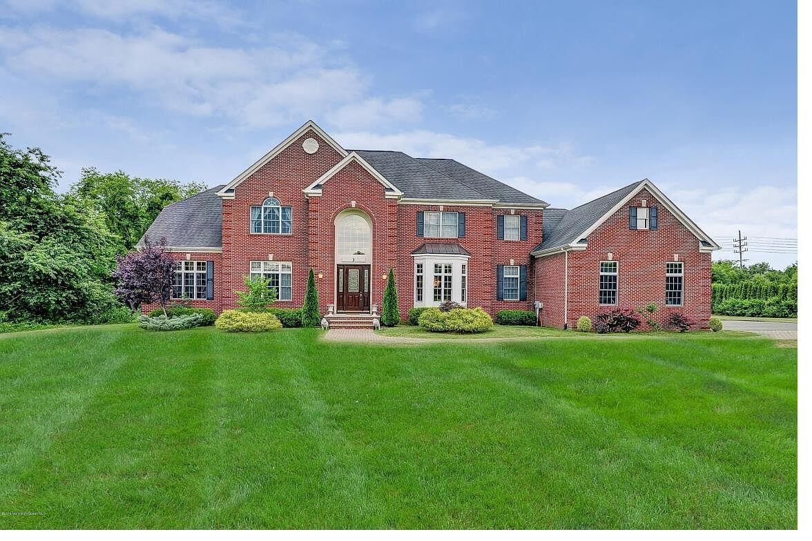 A red brick colonial custom home with an arched entry in New Jersey