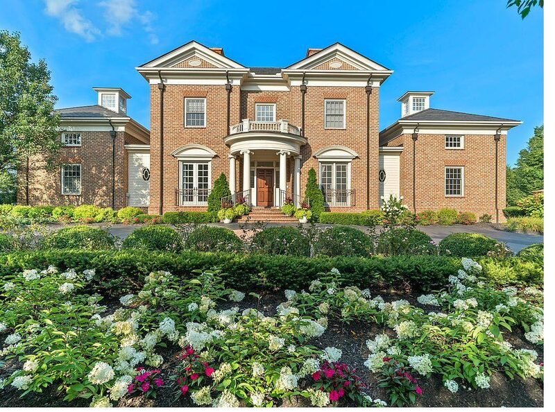 Red brick colonial home with white trim and dormers