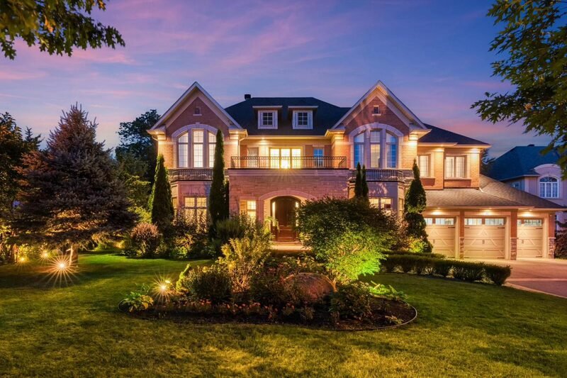 A brick and shingle luxury colonial at dusk