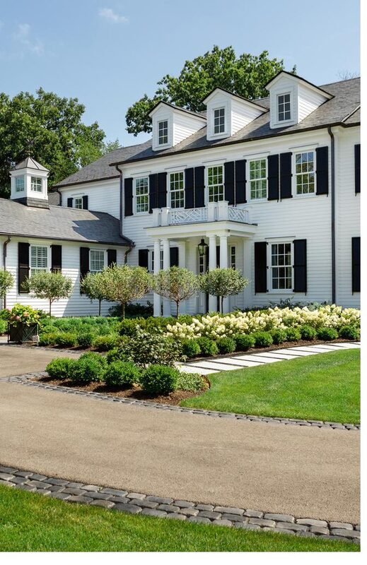 A tall white colonial with black shutters