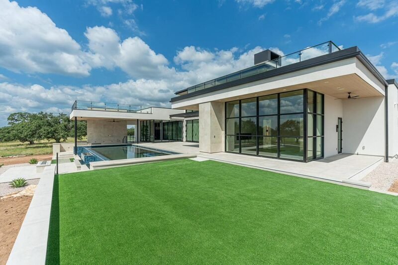 Modern custom home with glass walls and a pool